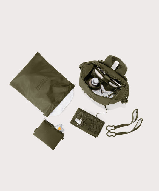 Dagne Dover small Indi Diaper Backpack in dark moss showing it's water resistant bag, interior pockets, and changing mat.