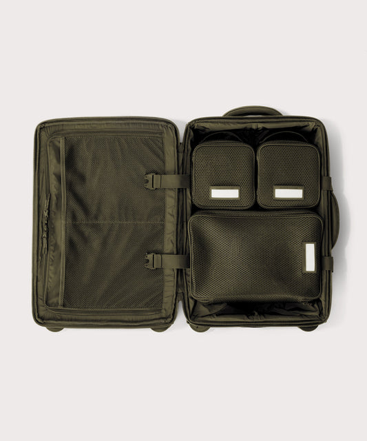 Top down of Seattle carry-on rolling luggage 20.5” in dark green with interior divider zipped and packing cubes packed into the right side.